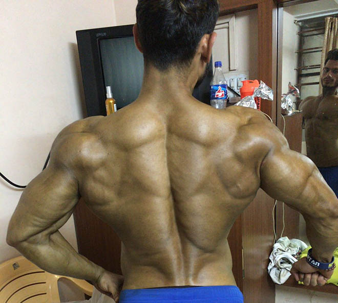 Premium Photo | Sporty handsome bodybuilder guy with muscular rear and back  poses and shows muscle against a dark background in the studio